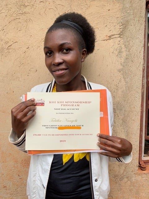 Young woman holding scholarship certificate