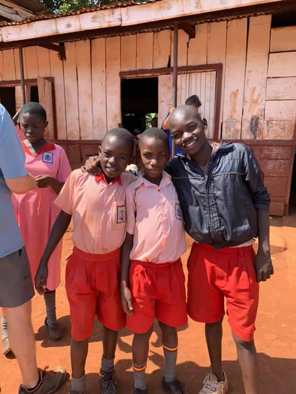 Three boys outside Busoga school